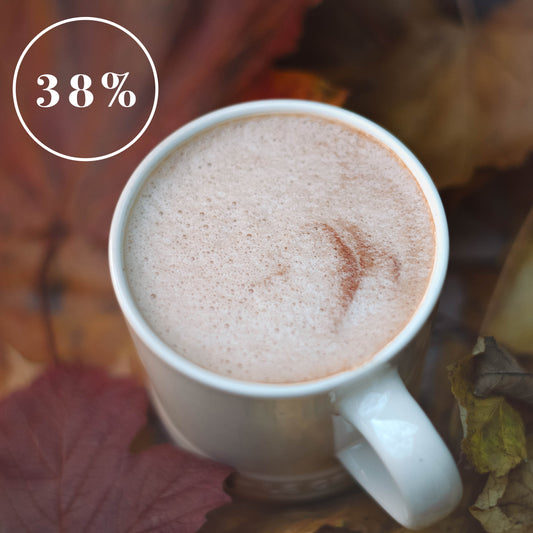 White mug of 38% organic hot chocolate with autumn leaves in the background.