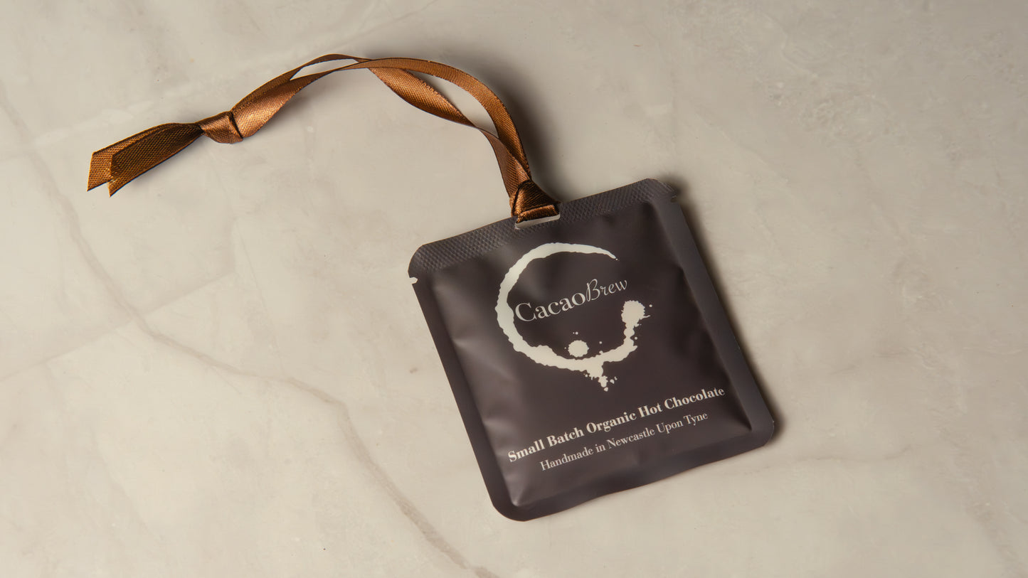 Organic Hot Chocolate single-serve sachet with luxurious brown ribbon.